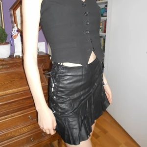 Faux läderkjol med snörning🖤 - Liten minikjol i PU-läder med snörning på sidan. Lite skrynklig på bilden men fixas lätt med steamer. 🖤🖤 OBS om du köper mer än ett plagg är frakten gratis! 