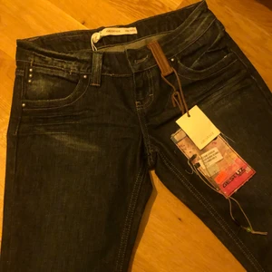Snygga lågmidjade jeans  - Supersnygga mörkblåa lågmidjade raka jeans från Gestuz. Tycker själv de är supersnygga men de är tyvärr för små för mig. De ser lite slitna ut på bilden men de är i nyskick. De har dessutom snygga dragkjedjor på fickorna.