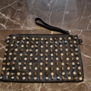 Tuff handväska med nitar - En handväska som sticker ut från mängden med sina nitar och detaljer,  31 cm lång och ca 20 cm bred. Nyskick. Kan skickas.