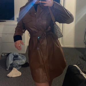 Kavajklänning - En brun kavajklänning som även går att ha som jacka säljes då den aldrig kommit till användning. från newyorker i storlek S. 
