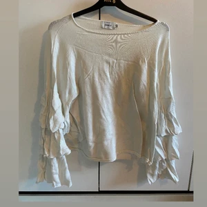 Tröja med volanger  - Fin tröja med ärmar med volanger. Creme-färgad. Fint skick. Köparen står för frakt. 