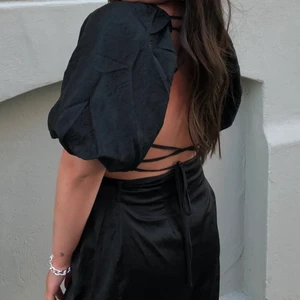 Svart topp - En otrolig svart topp med öppen rygg (med knyte) 😍. Använd fåtal gånger men ser helt oanvänd ut. Från Na-Kd i strl S men passar även M