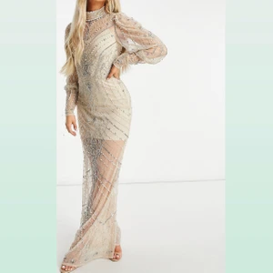 Storlek 40/42 - Prydd med paljetter och fuskpärlor Hög krage Långa ärmar Nyckelhålsöppning med knapp baktill Regular passform Normal i storleken.                                                               Säljer min klänning som i väldigt bra sick, använd endast några timmar. Köpt för 2500kr säljer för 1900kr Storlek 40/42 finns i Stockholm  