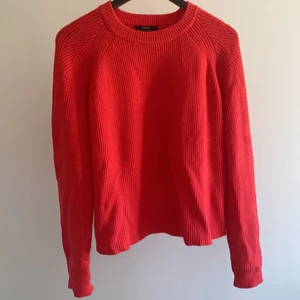 Röd stickad tröja - Säljer en superfin röd stickad tröja. På bilderna ser det ut som att den är mer åt ett varmt oranget håll. Men tröjan är egentligen en mer kall röd färg med lite rosa underton. Tröjan är perfekt nu till våren, eller till sena sommarkvällar!