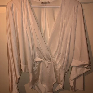 Vit body  - En vit omlottbody, storlek S halvstring där bak