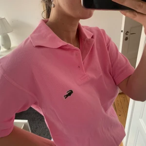 Lacoste piké  - Rosa piké från lacoste, egentligen herrmodell men är snygg att ha over sized! Använd 2-3 gånger och bra skick!:) Beroende på önskad passform kan den passa S-M/L
