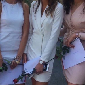 Kavaj klänning - Vit kavajklänning som kompletterar kroppen väldigt fint! Perfekt för student, avslutningar, middagar och fest. Endast använd 2 gånger och därav i bra skick. Försluts med dragkedja och en knapp