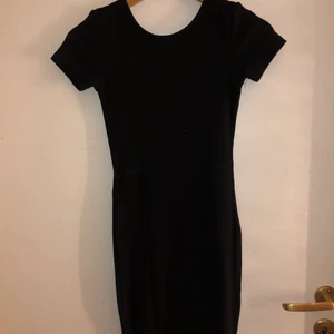 Tight ribbad T-shirt klänning med öppen rygg - Superskönt ribbad T-shirt klänning som slutar strax ovanför knäna. Den har en öppning i ryggen, men känns ändå påklädd. Använd max 3 gånger, och är i fint skick!
