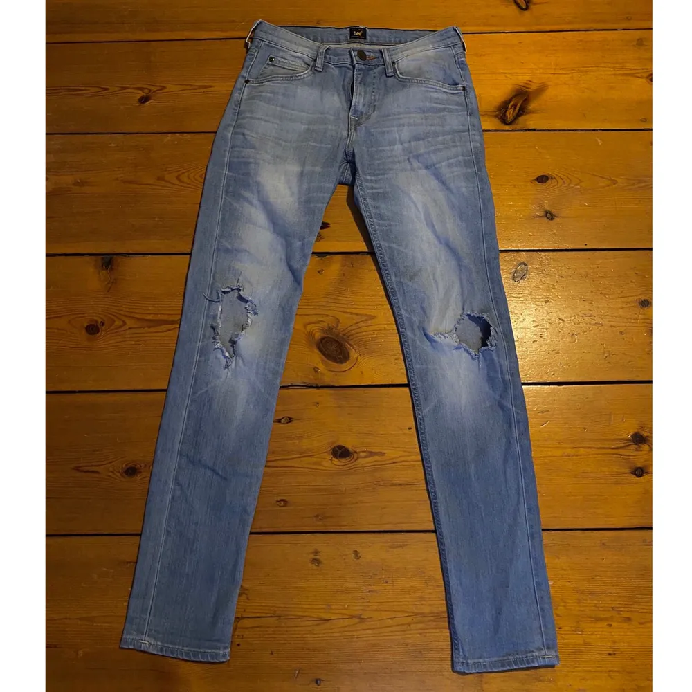Blåa lee jeans med egenklippta hål vid knäna. Jeans & Byxor.