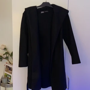 Kappa strl S från Zara  - Det är en svart kappa i strl S från Zara. Den har en huva samt band som kan knytas över höften/midjan. Jag själv tycker den är väldigt snygg, jag säljer den endast för att det inte är min stil. Den är använd 2 gånger sen jag köpte den i januari 2020, dvs att den är i gott skick. Den kostade 500kr. Längden på kappan går precis över knäna på mig iallafall (168 cm). Den har även fickor :) 