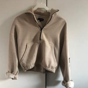 Croppad sweatshirt med dragkedja. Beige färg