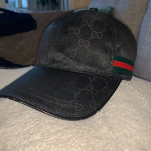 Gucci Keps  - En Svart Gucci keps köpte den för inte så länge sen den jag köpte den av sa att den var äkta och det är en jätte gammal modell typ den första modellen kan gå ner i pris vid snabb affär bra skick skriv om fler bilder eller vid intresse😁