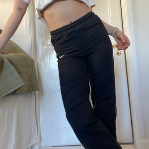 Vintage Tracksuitpants nike - Ett par vintage tracksuit träningsbyxor från Nike! De är medelhöga i midjan och går att knyta åt, det finns även en dragkedja längs benen nere vid ankeln. Storleken är L i barns killstorlek, men skulle säga att de passar en xxs-m beroende på önskad passform. Jag är 171cm lång och de slutar precis ovanför mina sneakers. Bara att fråga om du vill ha fler bilder eller andra frågor!