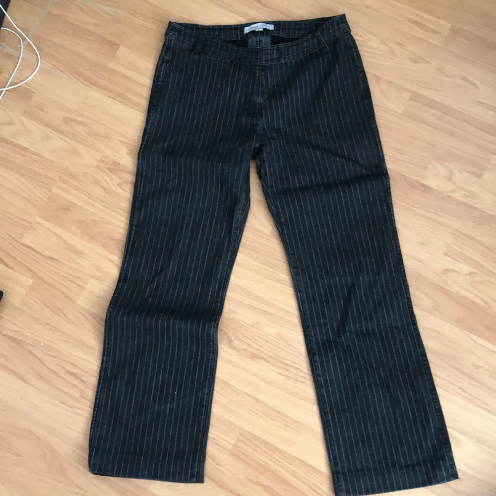 snygga lågmidjade svarta jeans med vita ränder i storlek 44 men sitter som M, köparen står för frakt💚. Jeans & Byxor.