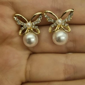 Fjärilsörhängen i guldfärg - Använda en gång. Guldfärgade. Stenarna glittrar i ljus.