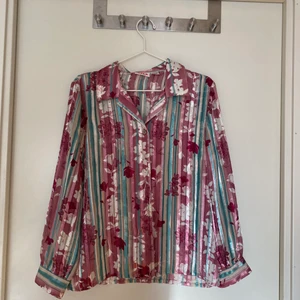 Transparant blommig vintage skjorta  - Rosa, lila, blå transparant vintage skjorta med blommor och randigt mönster. 