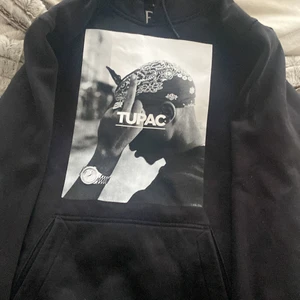 Tupac hoodie - Svart tupac hoodie köpt för 599kr säljs för 200kr. Den är inte använd så mycket och är fortfarande i fin kvalitet ända skavanken är att trycket är lite sprucket men de märks intr om man inte kollar noga och nära