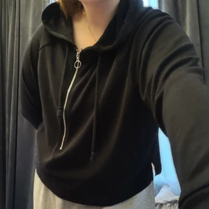 Svart Hoodie, BikBok - Tunn svart crop hoodie från Bikbok i storlek Medium. Sitter löst runt midjan och armarna, perfekt som lager-tröja när det blåser lite på sommarn men även som myskläder när man bara vill ta det lugnt<3 extra cool också med dragkedja och ring i fram. Haft den i garderoben några år men inte använt så ofta, är fortfarande i gott skick! Säljer eftersom jag inte längre använder den. Minns ej originalpris men säljer för det jag tycker känns rimligt.