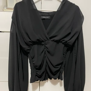 Tröja  - Svart topp med detaljer vid bröstet 