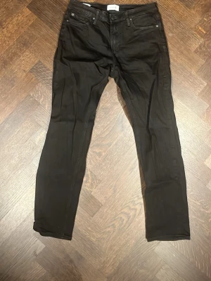 Svarta jeans - Snygga svarta jeans från jack and jones med klassisk femficksmodell och smal passform. Jeansen har raka ben passar 175