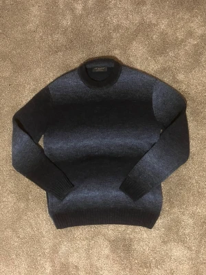 Unik blå stickad tröja - Otroligt unik blå tröja med lite olika nyanser vilket gör att den ser lite ”washed” ut. Tröjan är gjord av ull och är i bra skick. Den har inte några defekter. Tröjan är igentligen i storlek XS men passar mer S/M.  Skick: 9,5/10    Storlek: S/M