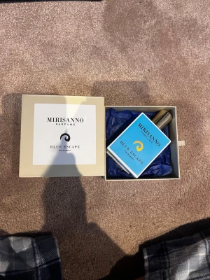 Mirisanno Blue Escape Eau de Parfum -  Helt ny Mirisanno Blue escape parfym endast sprutad 4 gånger typ men passade inte mig i smaken så lika bra att sälja den ny pris är 748 med frakt så mitt pris är 560 Fräsch parfym från Mirisanno, Blue Escape, i en stilren fyrkantig flaska med blå etikett och gulddetaljer. Kommer i en elegant beige presentask med matchande blått silkespapper. Perfekt för dig som gillar moderna och fräscha dofter.
