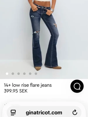 Blå low rise flare jeans Gina Tricot - Snygga blå low rise flare jeans från Gina Tricot med slitna detaljer och kontrastsömmar. Jeansen har låg midja, utsvängda ben och coola broderier på bakfickorna. Tillverkade i klassiskt denimtyg. Jag har sprätt upp längst ner i benen men annars likadana💗