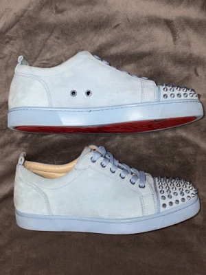 Christian Louboutin / loubs sneakers – baby blue – strl 43 – röda sulor - ljusblå - Tjena!😃 Säljer dessa sällsynta Christian Louboutin-sneakers i färgen baby blue. Mocka-material med nitar framtill och Louboutins ikoniska röda sulor🩸  Skorna är sparsamt använda och i fint skick. Skick: 7/10 – lite smutsiga men inget som påverkar helhetsintrycket.  ✔ Äkta Louboutin ✔ Storlek 43 ✔ Inga större skador ✔ Skickas snabbt  Pris kan diskuteras vid snabb affär. Hör av dig vid minsta fundering så svarar jag så fort jag kan🤝