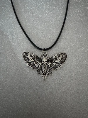 Svart halsband fjärildöskalle - Halsband som inte är i äkta silver/guld. Kedja är oftast 50cm men kan ibland komma i 45cm. Kedja är rostfritt stål, berlock oftast i zinklegering men kan även det i vissa fall vara rostfritt stål. Be gärna om mått på berlock om detta är viktigt då bilderna är missvisande när det gäller hur stora dom är! 🌹❤️  Allt är nytt även om de kan stå ”mycket bra skick” , detta mest för att Vinted inte ska fundera på varför jag bara har nya saker .  Bud accepteras inte 🥰🌹