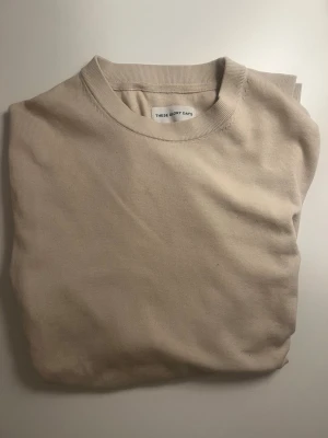 Beige sweatshirt från These Glory Days - Stilren beige sweatshirt från These Glory Days med rund halsringning och mjukt bomullsmaterial. Perfekt basplagg med enkel design och normal passform. Passar till allt och är superenkel att matcha med andra plagg.