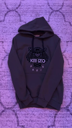 Mörkgrön Kenzo hoodie med tigertryck - Snygg mörkgrön hoodie från Kenzo med ikoniskt tigertryck och texten KENZO PARIS på bröstet.