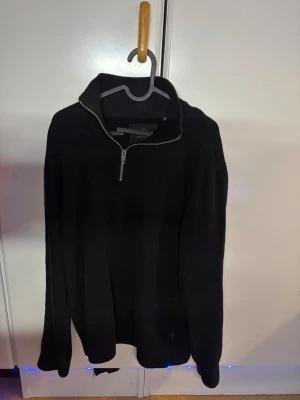 Svart stickad halvzip-tröja - Säljer en svart stickad tröja med halv dragkedja och hög krage. Tröjan har lång ärm och en enkel, clean design utan synliga loggor eller mönster. Perfekt för lager på lager och passar till det mesta i garderoben. Från jack&jones