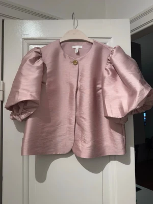 Rose pink blouse from H&M in S size - Never used blouse from H&M in S size. Color is rose pink. It has golden button on top and snap button in the front. Can be used as bolero or top.  Fabric is very soft, little shiny and look premium.  It has balloon sleeves and underneath lining.  Big for me as I wear XS, hence selling