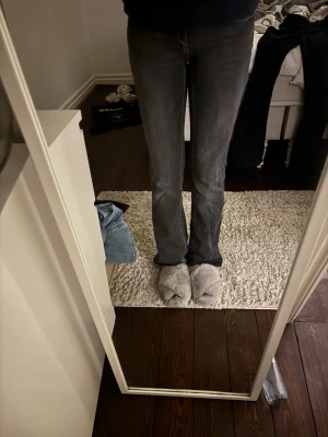 Mörkgrå bootcut jeans - Snygga mörkgrå bootcut jeans med klassisk femficksdesign och vita sömmar. Jeansen har en något utsvängd passform nertill . Perfekta för dig som gillar en avslappnad men trendig look.