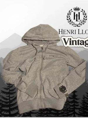 Grå zip hoodie från Henri Lloyd - Snygg grå hoodie från Henri Lloyd med dragkedja framtill och huva med dragsko. Mjuk insida i fleece och diskret logga på bröstet. Perfekt för chill dagar eller när du vill ha en enkel och stilren look.
