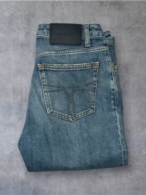 Tiger of Sweden Jeans - Klassiska blå jeans från Four of a Kind med raka ben och femficksmodell. Jeansen har en snygg tvättad look, kontrastsömmar och en svart patch bak i midjan. Perfekta till vardags för en avslappnad stil.