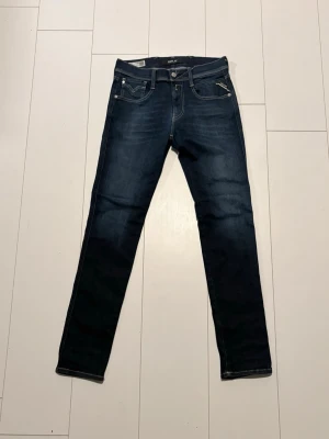 Mörkblå Replay jeans straight fit - Snygga mörkblå jeans från Replay med klassisk femficksdesign och raka ben. Jeansen har kontrastsömmar och Replay-logga vid fickan. Perfekta för dig som gillar en tidlös och enkel stil.