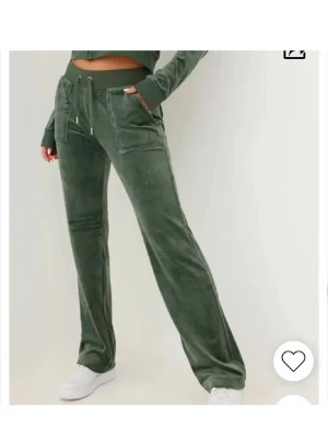 Juicy byxor  - Mysiga gröna mjukisbyxor i velour med raka ben och snörning i midjan. Byxorna har fickor framtill och en relaxed passform som är perfekt för chill dagar. Matcha med sneakers för en avslappnad look.