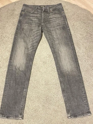 Mörkgråa Jack&Jones jeans - Snygga grå Jack&Jones jeans med normal passform och klassisk femficksdesign. Säljes då dom är för liten.