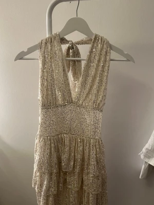 Meet me there klänning - Säljer denna superfina halterneck klänningen med snörning i nacken och paljetter. Aldrig använd då den tyvärr inte passade på mig, därav prislappen kvar, kostar 539 kr ordinarie. Stretchig i materialet💞bara att höra av sig vid funderingar