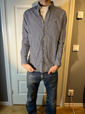 Ralph lauren skjorta  - Säljer en snygg blå rutig Ralph lauren skjorta i toppen skick! Modellen på bilden är 183 och väger 65kg. Hör av er vid frågor!