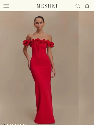 Balklänning Meshki - Röd långklänning från Meshki med offshoulder och volangdetaljer upptill. Klänningen har en figurnära passform och knytning framtill. Säljer då S satt bättre än M på mig, så inga defekter utan som helt ny med prislapp kvar. OBS! Jag har storlek S på sista bilden och stoppat in snörena som också går att göra :) Nypris: 1500 + tull. 