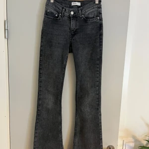 Lågmidjade bootcut jeans  - Lågmidjade bootcut jeans från Gina tricot i storlek 32. Grå / svarta i färgen. Dom är uppsprättade längst ner och passar mig som är ca 169 i längden💕