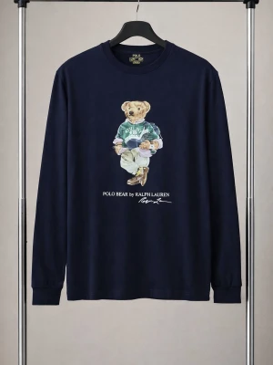 Ralph Lauren Mörkblå långärmad Polo Bear t-shirt - Snygg mörkblå långärmad t-shirt från Ralph Lauren med ikoniskt Polo Bear-tryck på bröstet. Klassisk rund halsringning och mjukt bomullsmaterial som känns skönt mot huden. Perfekt för dig som gillar streetwear och vill ha en unik detalj i garderoben.