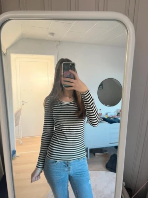 Svartvit randig långärmad topp - Säljer en svartvit långärmad topp från H&M med klassiskt horisontellt randigt mönster. Mycket fint skick och har inga defekter! I storlek S