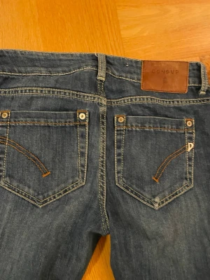 Blå slim fit jeans från Dondup - Snygga blå jeans från Dondup med klassisk femficksdesign och kontrastsömmar. Modellen är skinny med smal passform och raka ben. Jeansen har en mörk tvätt och är tillverkade i jeansmaterial med detaljer som metallnitar och läderpatch bak i midjan. En lite hammare model dock