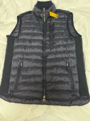 Parajumper väst i mörkblå - En jätte fin och mycket sparsamt använd parajumper väst som är i mörkblå och har inte en ända lilla repa. Köpte den för ungefär 2 månader sen och det har bara blivit för kallt för att använda den. Kvittot är spårlöst försvunnen på nått sätt men annars en skit fin väst.