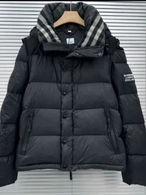 Burberry jacka - Svart pufferjacka från Burberry med avtagbara ärmar så den kan användas som väst. Jackan har ett rutigt foder i kragen, dragkedjor och knappar med Burberry-logga. Fylld med dun och har två sidofickor med dragkedja. Perfekt för kalla dagar.