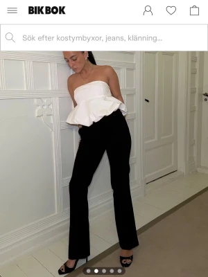 Svarta kostymbyxor BikBok - Vera flare kostymbyxa från BikBok, storlek 40. Dom har låg midja, raka ben som är lätt utsvängda nedtill och pressveck. Benlängd mätt längs innersöm: 82 cm. True to Size. Använt fåtal gånger. Köparen står för frakten 🩷