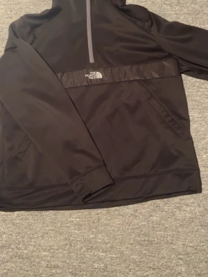The North Face Hoodie- Svart-storlek XL - Snygg och stilren The North Face Hoodie i svart.Använd några gånger men i mycket bra skick – inga hål, inga fläckar och inget slitage. Allt fungerar som det ska (dragkedja, luva, sömmar).